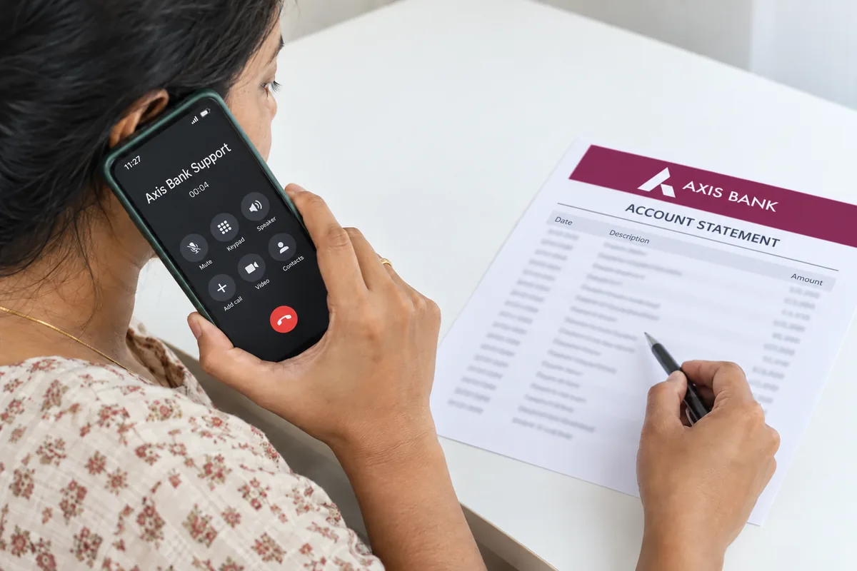A person calls Axis Bank Support while checking an Axis account statement